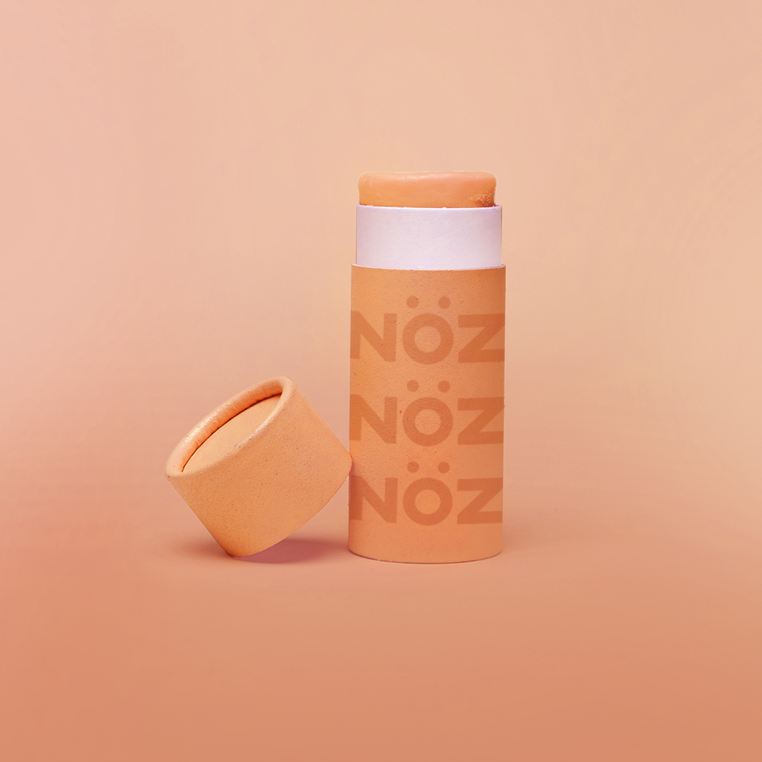 Orange color zinc NOZ brand sunscreen stick.